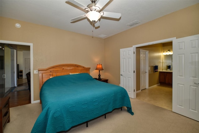 carpeted bedroom featuring ceiling fan and ensuite bath