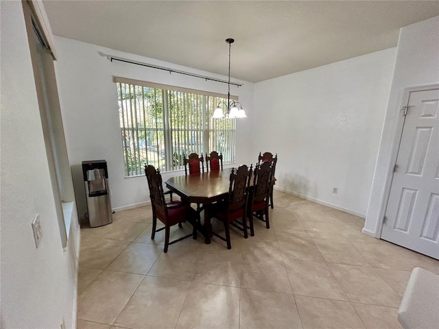 dining space with baseboards, light tile patterned floors, and an inviting chandelier