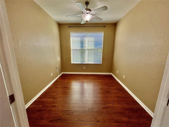 spare room with a ceiling fan, a textured wall, baseboards, and wood finished floors