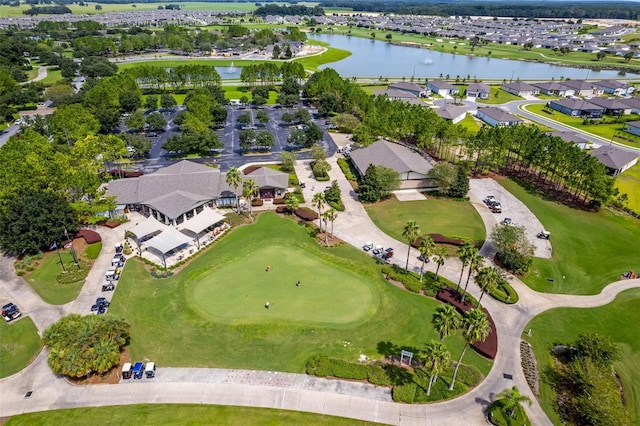 drone / aerial view with a residential view, view of golf course, and a water view