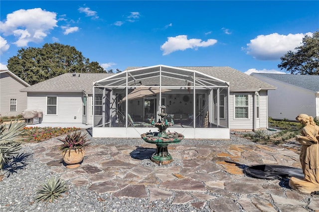 rear view of house with a patio and glass enclosure