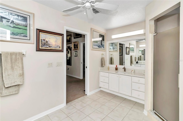 bathroom featuring ceiling fan, vanity, tile patterned flooring, and a textured ceiling