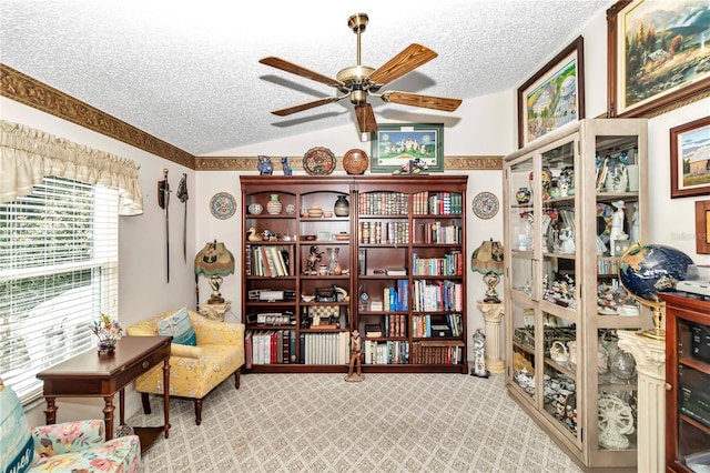 living area featuring vaulted ceiling, light carpet, ceiling fan, and a textured ceiling