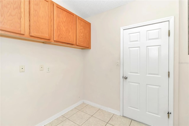 laundry area featuring light tile patterned floors and a textured ceiling