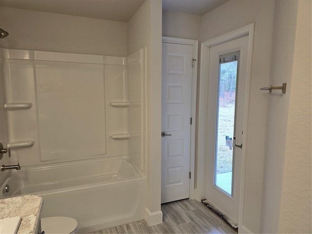 full bathroom with vanity, hardwood / wood-style flooring, a wealth of natural light, and tub / shower combination