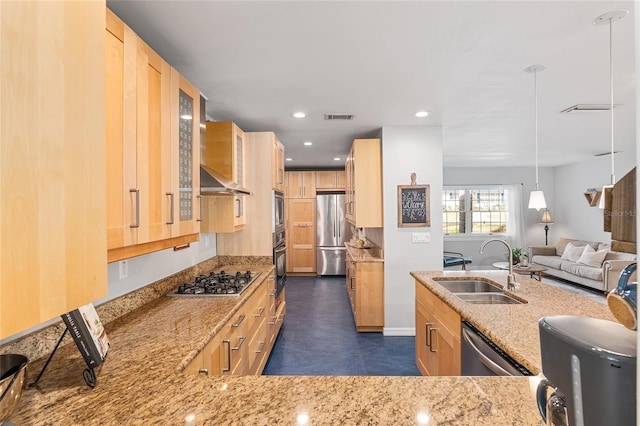 kitchen with pendant lighting, sink, stainless steel appliances, light stone countertops, and light brown cabinetry