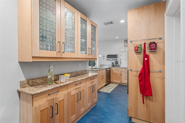 kitchen featuring dishwasher, sink, light brown cabinets, and light stone counters