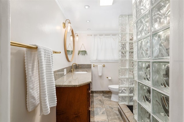 bathroom with crown molding, walk in shower, vanity, and toilet