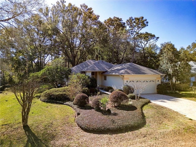 ranch-style home featuring a garage and a front yard