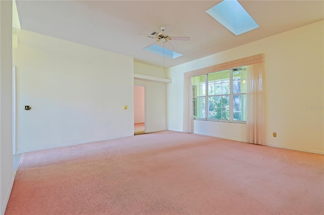 carpeted empty room featuring ceiling fan and a skylight