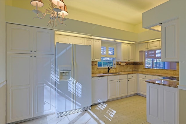 kitchen with sink, white cabinets, pendant lighting, white appliances, and backsplash