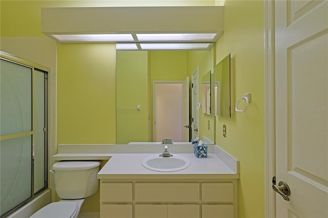 full bathroom with bath / shower combo with glass door, vanity, and toilet