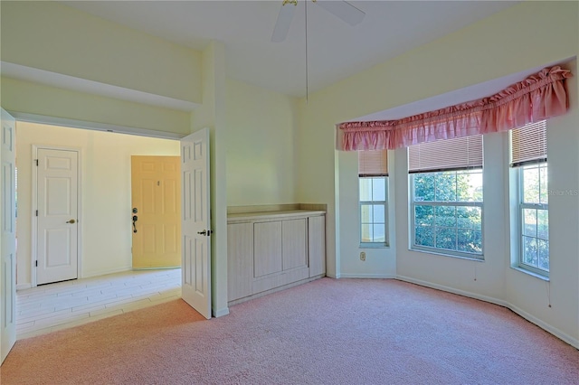 empty room with light colored carpet and ceiling fan