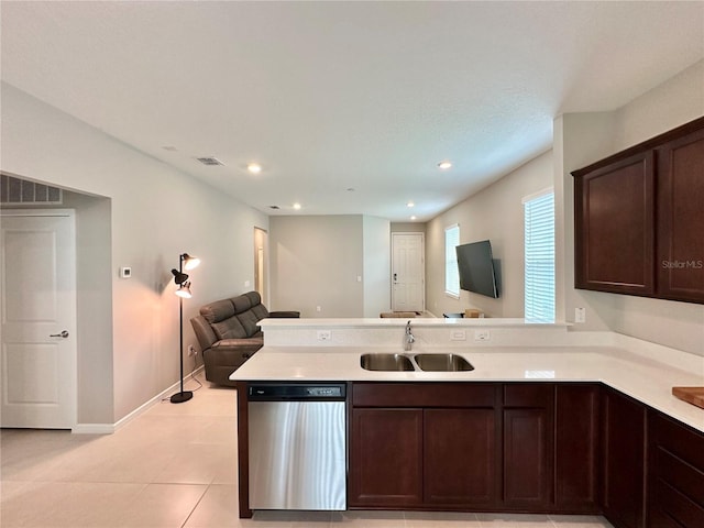 kitchen featuring sink, dishwasher, dark brown cabinetry, light tile patterned flooring, and kitchen peninsula