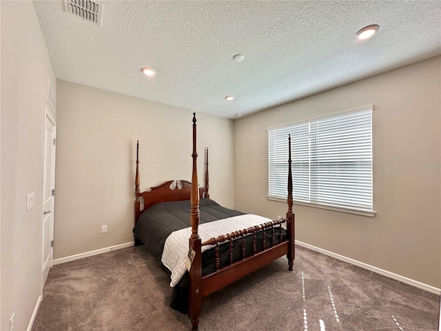 bedroom featuring a textured ceiling and dark carpet