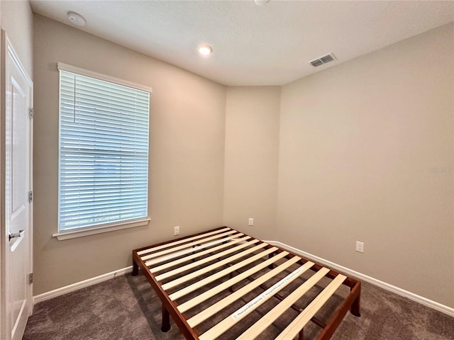 unfurnished bedroom featuring dark colored carpet