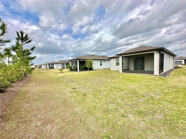 rear view of property with a yard and a sunroom