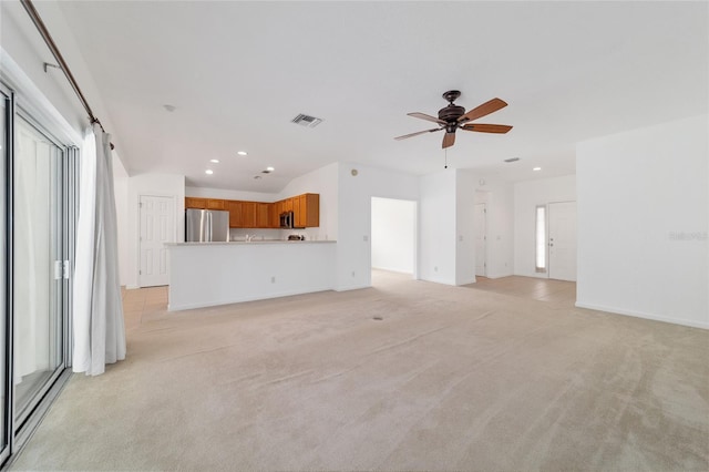 unfurnished living room featuring ceiling fan and light carpet