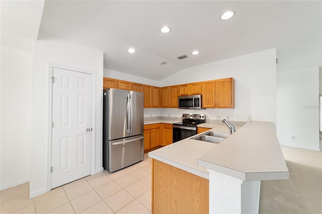 kitchen featuring vaulted ceiling, appliances with stainless steel finishes, light tile patterned flooring, sink, and kitchen peninsula