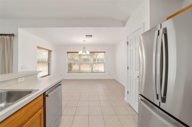 kitchen with an inviting chandelier, appliances with stainless steel finishes, hanging light fixtures, and light tile patterned floors