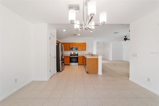 kitchen with pendant lighting, sink, stainless steel appliances, vaulted ceiling, and kitchen peninsula