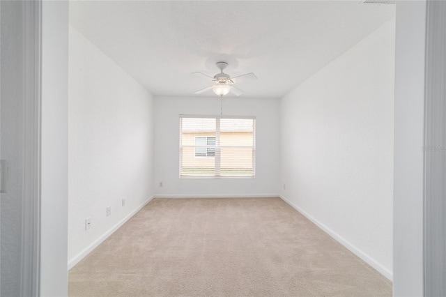 spare room with light colored carpet and ceiling fan