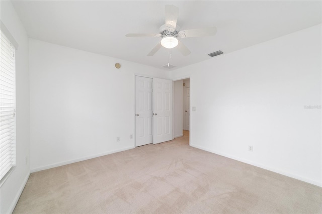 carpeted empty room with plenty of natural light and ceiling fan