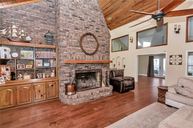 living room with high vaulted ceiling, ceiling fan, wood ceiling, light hardwood / wood-style floors, and a brick fireplace