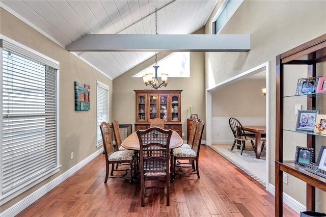 dining space with vaulted ceiling with beams, hardwood / wood-style floors, wooden ceiling, and an inviting chandelier