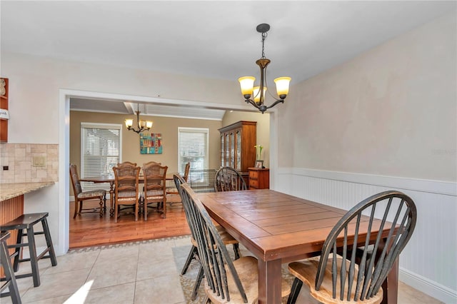 tiled dining space featuring an inviting chandelier