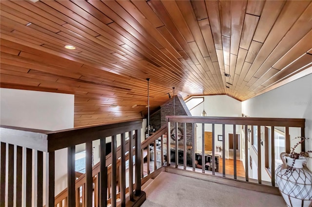 corridor featuring a healthy amount of sunlight, vaulted ceiling, carpet, and wooden ceiling