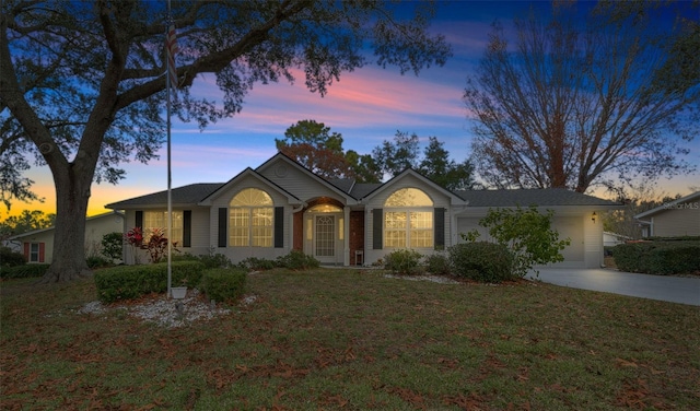 single story home featuring a yard and a garage