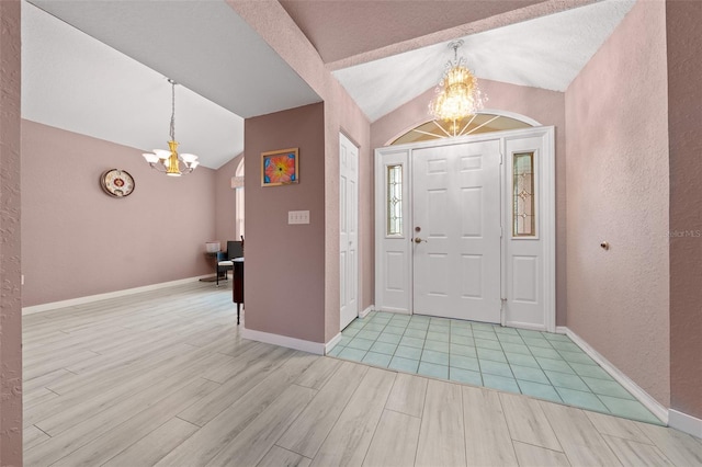 foyer featuring lofted ceiling, a notable chandelier, and light hardwood / wood-style flooring