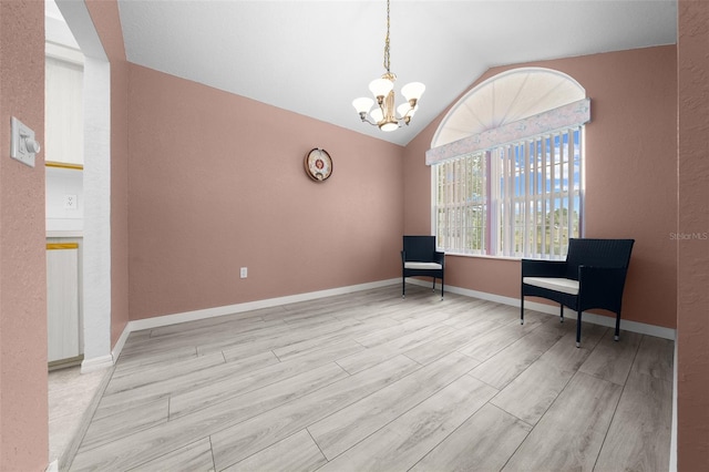 unfurnished room with vaulted ceiling, a chandelier, and light wood-type flooring