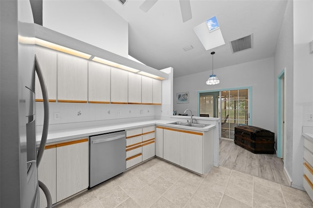 kitchen featuring sink, kitchen peninsula, pendant lighting, stainless steel appliances, and backsplash