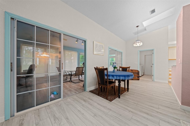 dining room with lofted ceiling with skylight