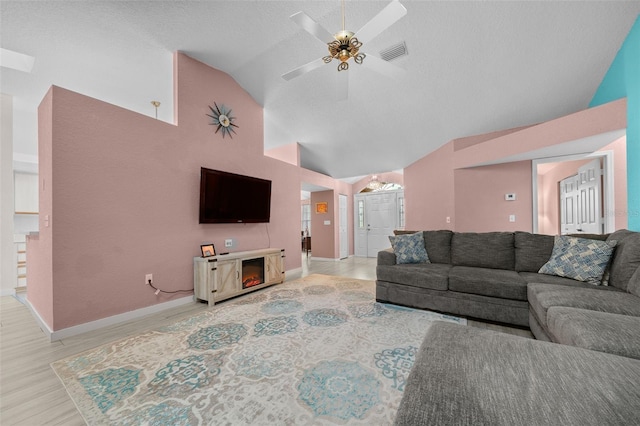 living room featuring high vaulted ceiling, a textured ceiling, ceiling fan, and light hardwood / wood-style flooring