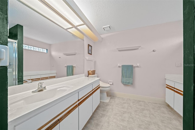 bathroom with walk in shower, vanity, toilet, and a textured ceiling