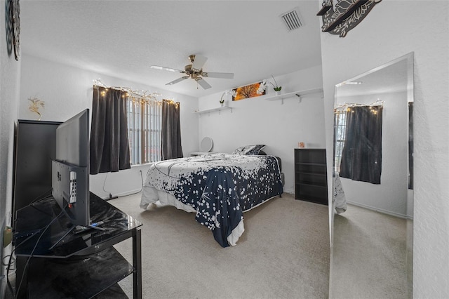 carpeted bedroom featuring a textured ceiling and ceiling fan