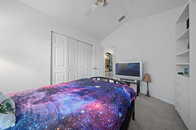 bedroom featuring lofted ceiling, a closet, ceiling fan, and carpet flooring