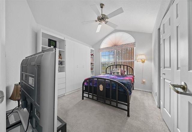 carpeted bedroom featuring lofted ceiling, a textured ceiling, and ceiling fan