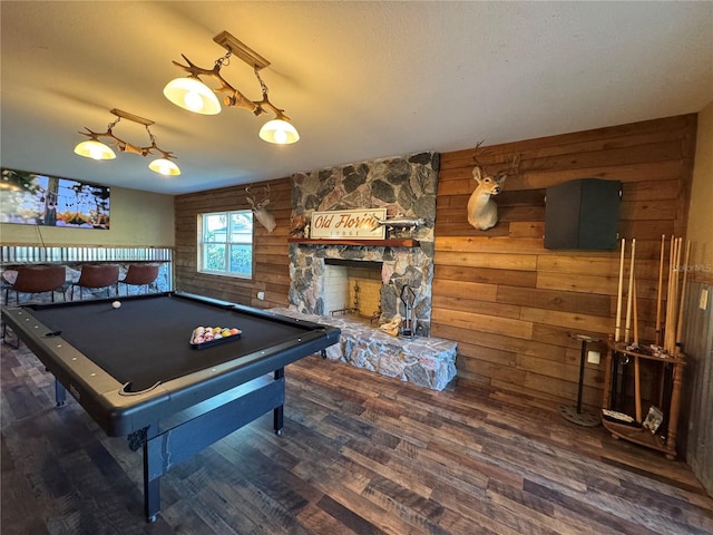 recreation room with bar, pool table, dark hardwood / wood-style floors, a fireplace, and log walls