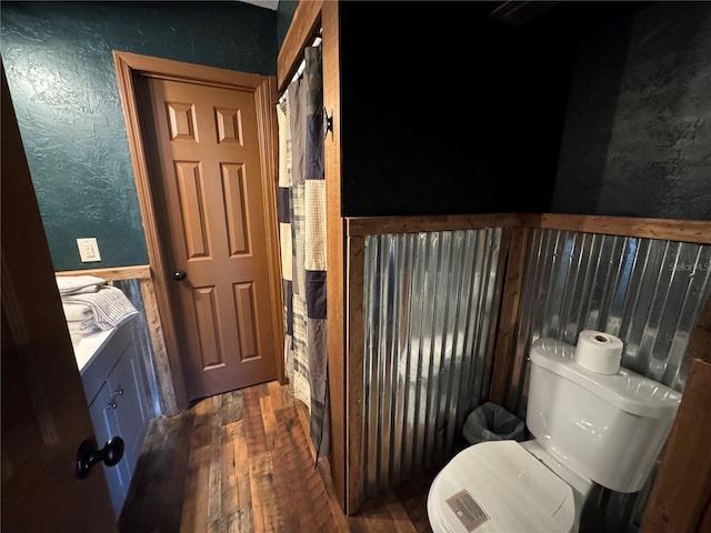 bathroom with hardwood / wood-style flooring, vanity, and toilet