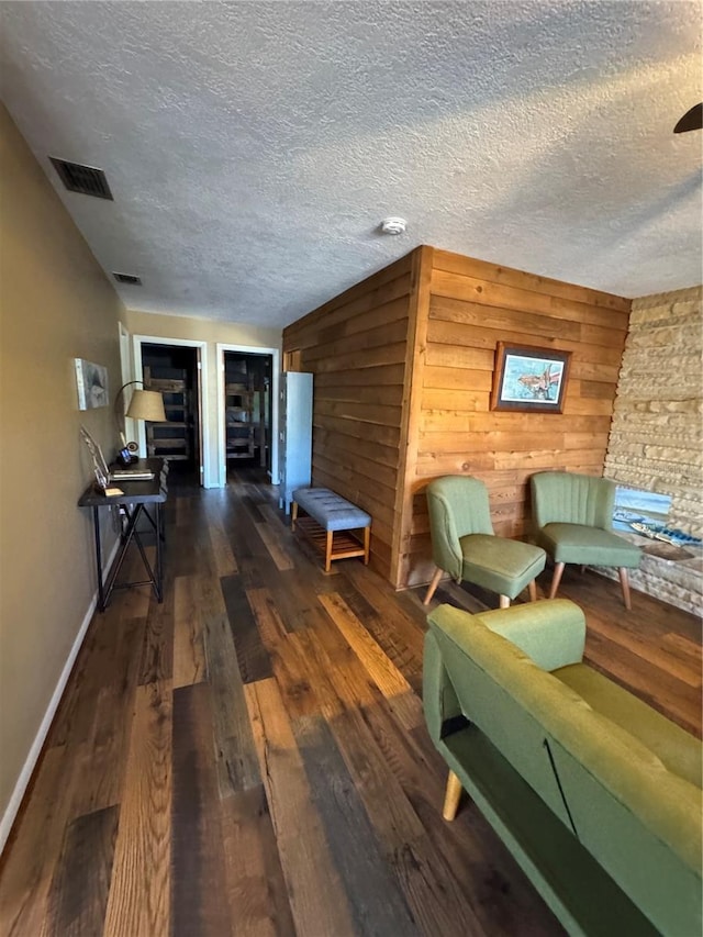 unfurnished living room featuring wooden walls and dark hardwood / wood-style flooring