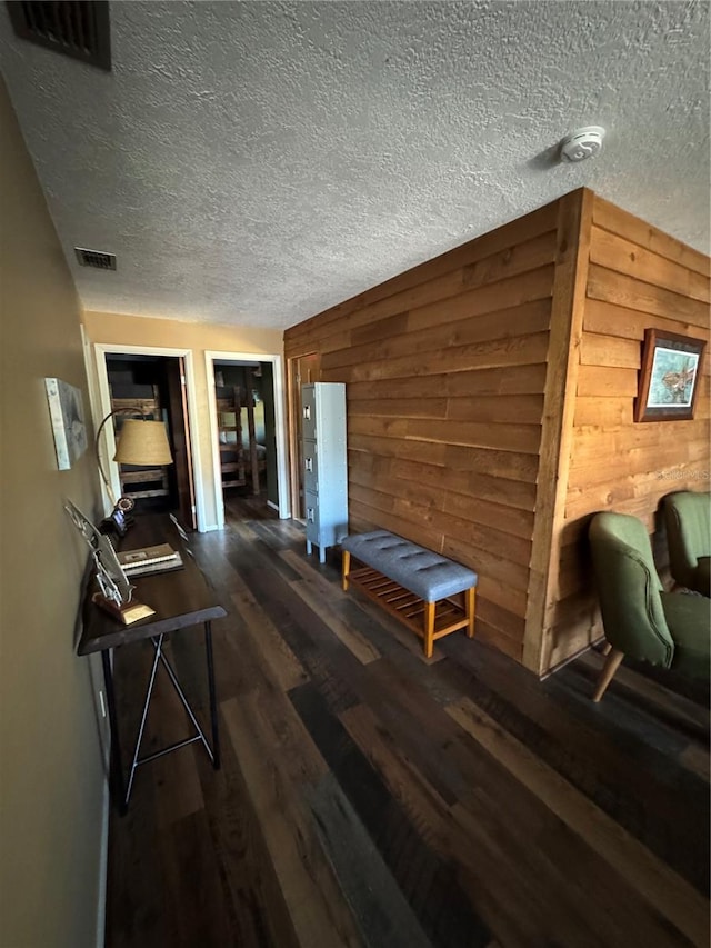 corridor with dark hardwood / wood-style floors and wooden walls