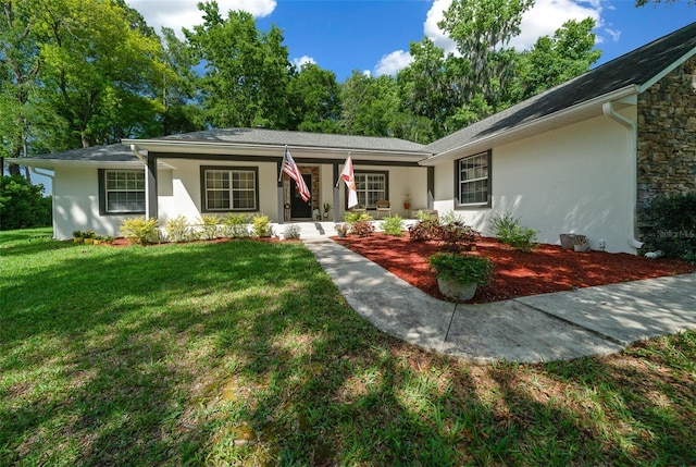 ranch-style home featuring covered porch and a front yard