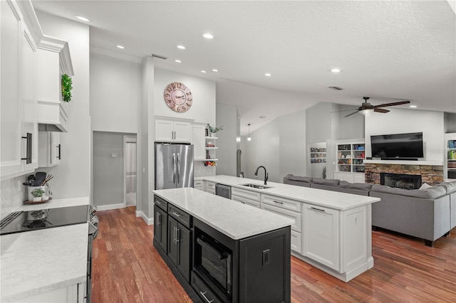 kitchen with appliances with stainless steel finishes, a center island, sink, and white cabinets