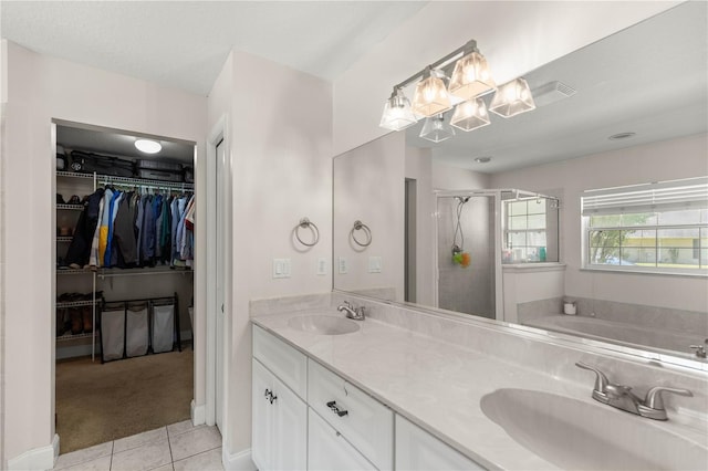 bathroom featuring tile patterned flooring, vanity, and plus walk in shower