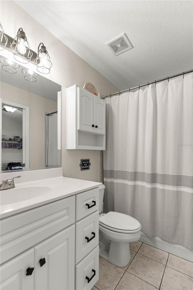 full bathroom featuring vanity, toilet, shower / bath combo, tile patterned floors, and a textured ceiling