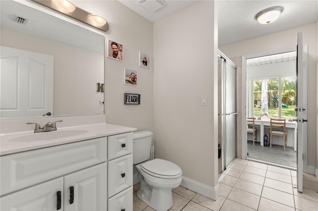 bathroom featuring vanity, tile patterned floors, toilet, and walk in shower